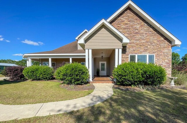 1621 Adkinson Rd, Newton, AL 36352 - view of front facade featuring a front lawn, stone siding, and covered porch
