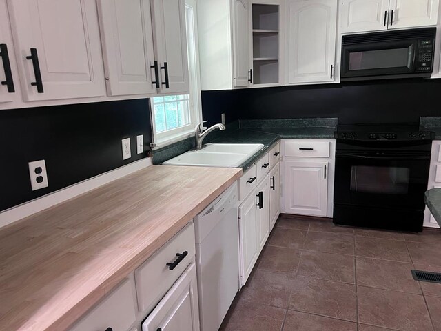 kitchen featuring white cabinetry, sink, dark tile patterned floors, butcher block countertops, and black appliances