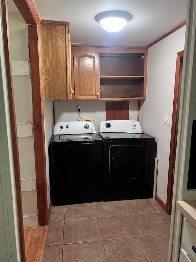 laundry room featuring tile patterned flooring, washer and dryer, cabinets, and ornamental molding