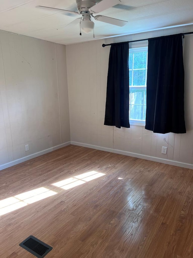 unfurnished room with ceiling fan and wood-type flooring