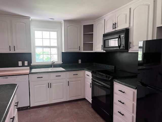 kitchen featuring black appliances, white cabinetry, sink, and dark tile patterned flooring