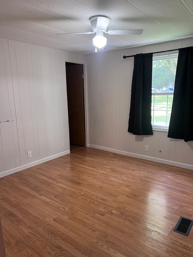 empty room featuring a textured ceiling, hardwood / wood-style flooring, and ceiling fan