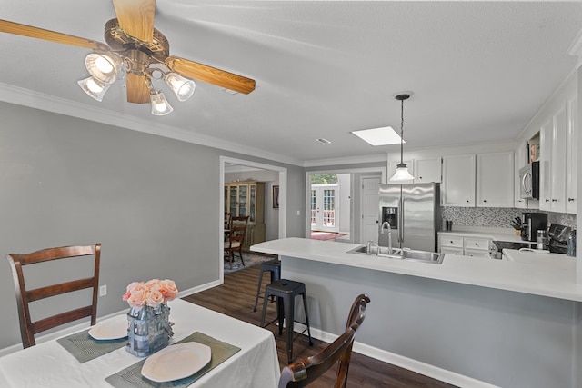 102 Lindsey Ln, Dothan, AL 36305 - dining space with dark wood-type flooring, crown molding, a skylight, and baseboards