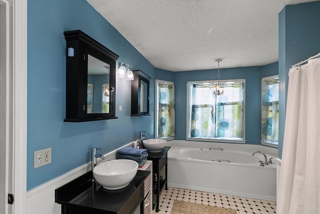 102 Lindsey Ln, Dothan, AL 36305 - full bathroom featuring a bath, a textured ceiling, double vanity, and a chandelier