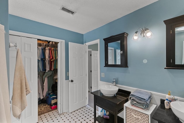 102 Lindsey Ln, Dothan, AL 36305 - full bath with a wainscoted wall, a spacious closet, a textured ceiling, tile patterned floors, and vanity