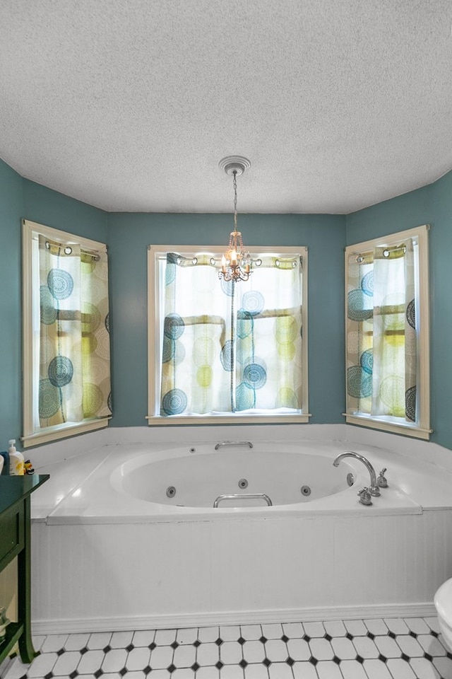 102 Lindsey Ln, Dothan, AL 36305 - bathroom with a chandelier, a tub with jets, and a textured ceiling