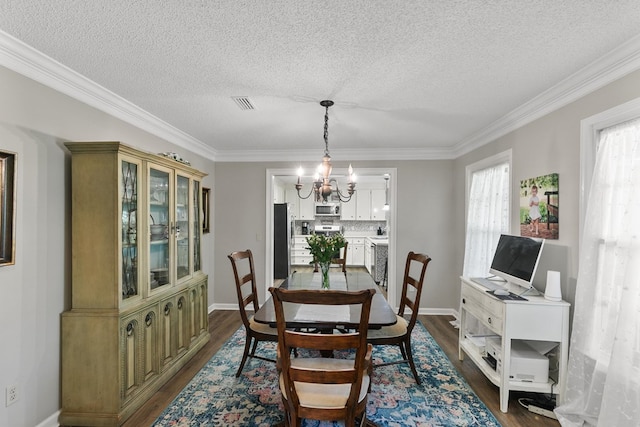 102 Lindsey Ln, Dothan, AL 36305 - dining space with dark wood-style flooring, a chandelier, crown molding, a textured ceiling, and baseboards