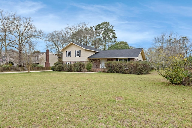 split level home with a front yard and fence