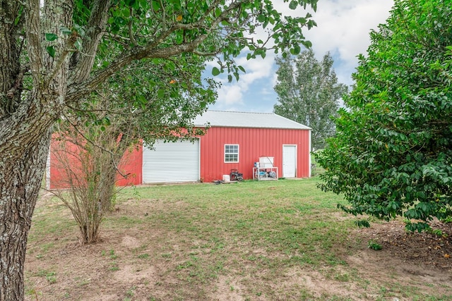 view of yard with a garage and an outbuilding