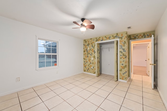 unfurnished bedroom featuring light tile patterned floors, a closet, and ceiling fan