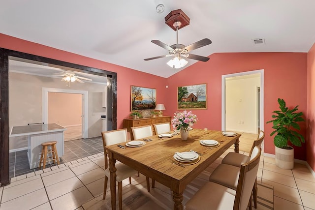 dining room featuring ceiling fan, light tile patterned floors, and vaulted ceiling