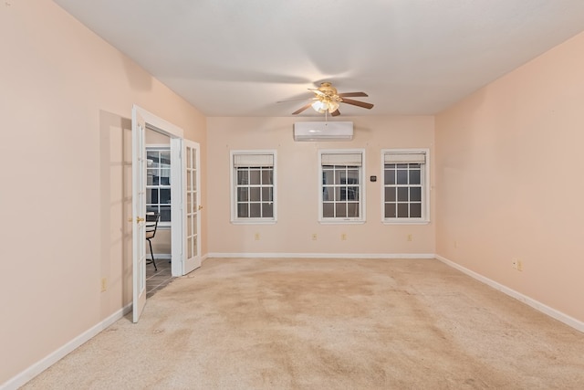 carpeted spare room with an AC wall unit, ceiling fan, and french doors