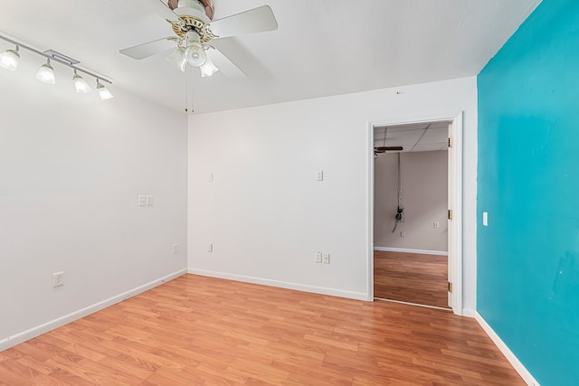 spare room with ceiling fan and light wood-type flooring