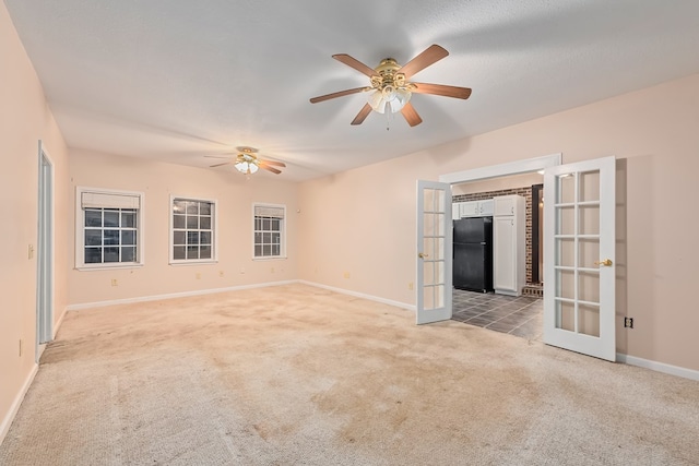 unfurnished living room featuring french doors, light colored carpet, and ceiling fan