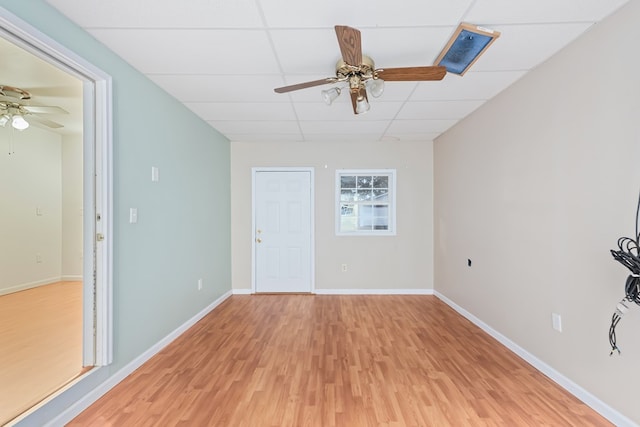 unfurnished room featuring a paneled ceiling, ceiling fan, and light hardwood / wood-style floors