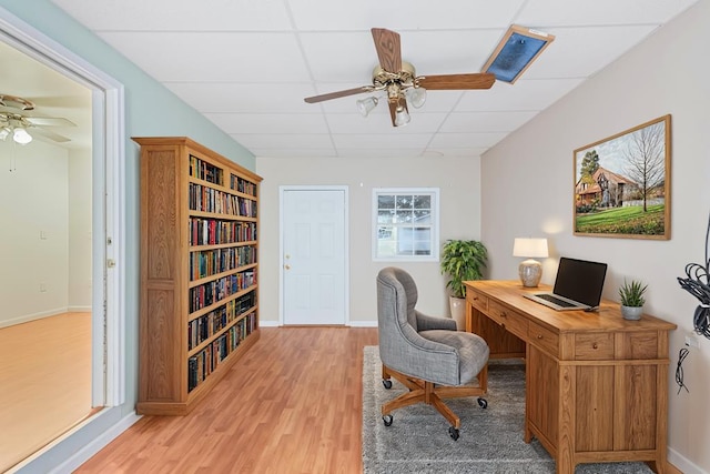 office area featuring a paneled ceiling, light hardwood / wood-style floors, and ceiling fan