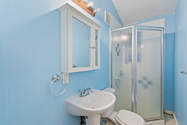 bathroom with a shower with shower door, toilet, lofted ceiling, and sink