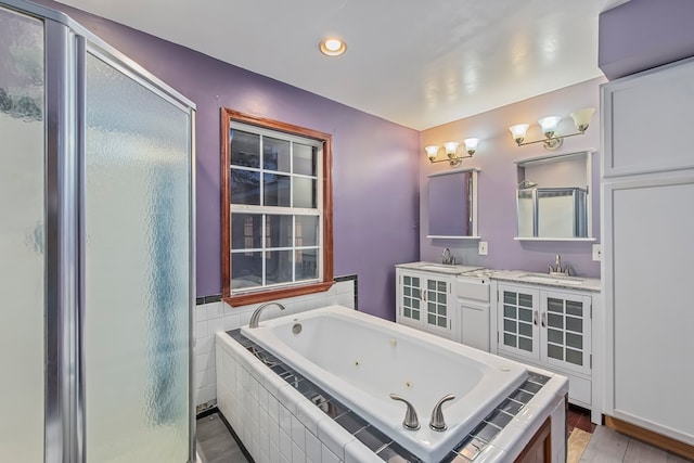 bathroom with hardwood / wood-style floors, vanity, and shower with separate bathtub