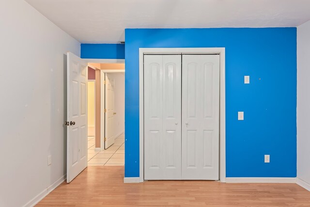 unfurnished bedroom featuring light wood-type flooring and a closet