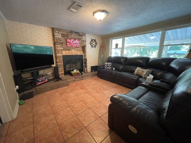 living room with light tile patterned floors, a textured ceiling, and a stone fireplace