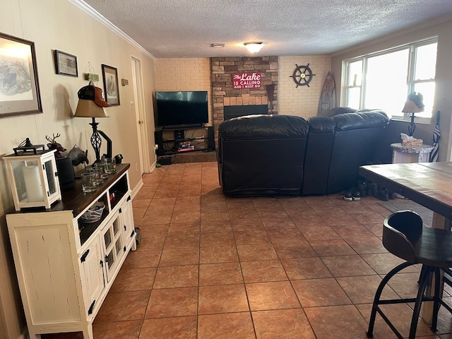 living room featuring a fireplace, a textured ceiling, dark tile patterned floors, and crown molding