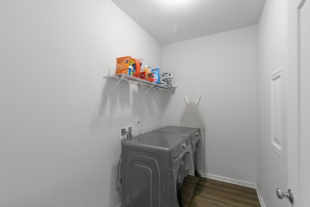 clothes washing area featuring separate washer and dryer, baseboards, laundry area, and dark wood-style floors