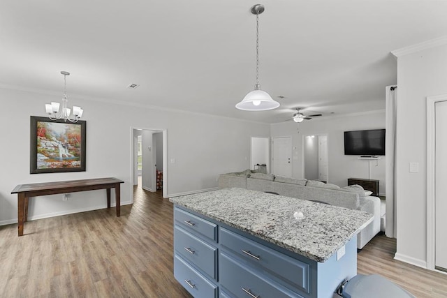 kitchen with crown molding, open floor plan, light wood-type flooring, blue cabinets, and ceiling fan with notable chandelier