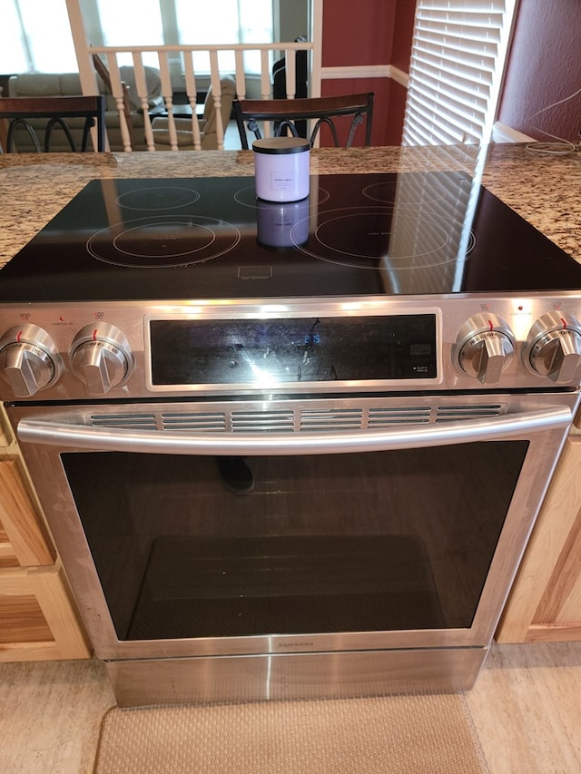 interior details featuring light brown cabinetry and high end stainless steel range oven