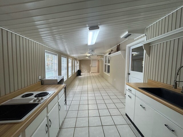 kitchen with ceiling fan, white cabinetry, sink, and light tile patterned floors