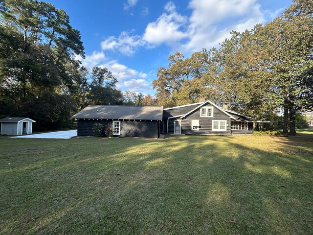 view of front of home featuring a front yard and a storage unit