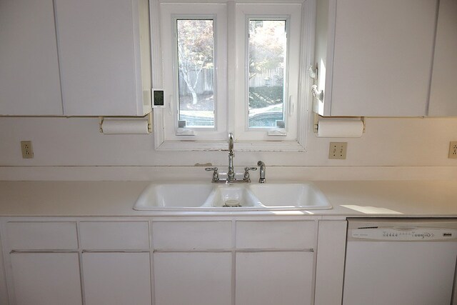 room details featuring dishwasher, white cabinets, and sink