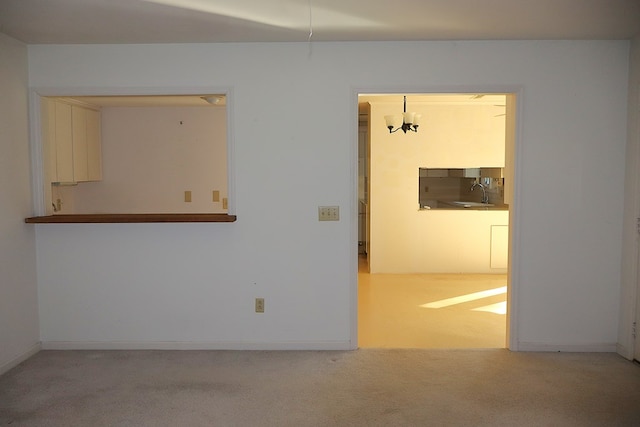 empty room with sink and light colored carpet