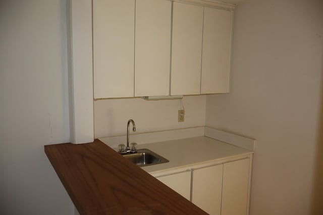 kitchen featuring white cabinets and sink