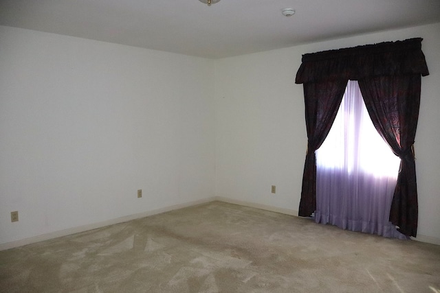 spare room featuring light carpet