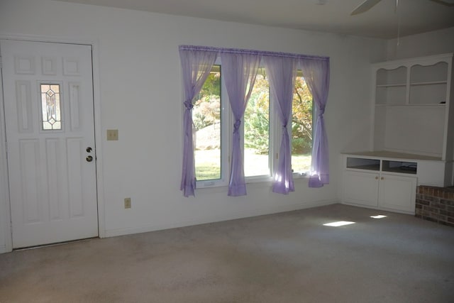 entryway with light colored carpet and ceiling fan