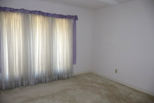 spare room with light colored carpet and a textured ceiling