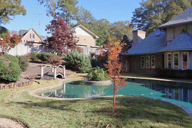 view of swimming pool with a yard