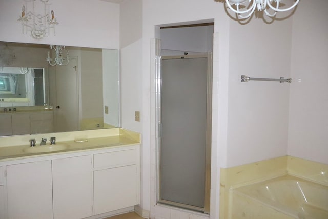 bathroom featuring separate shower and tub, vanity, and an inviting chandelier