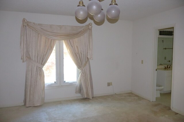 carpeted empty room with a chandelier