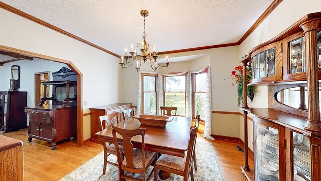 1109 Sanitary Dairy Rd, Cowarts, AL 36321 - dining area featuring ornamental molding, a notable chandelier, a textured ceiling, and light wood-type flooring