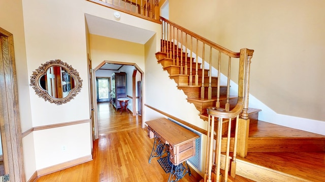 1109 Sanitary Dairy Rd, Cowarts, AL 36321 - stairway featuring a towering ceiling, arched walkways, baseboards, and wood finished floors