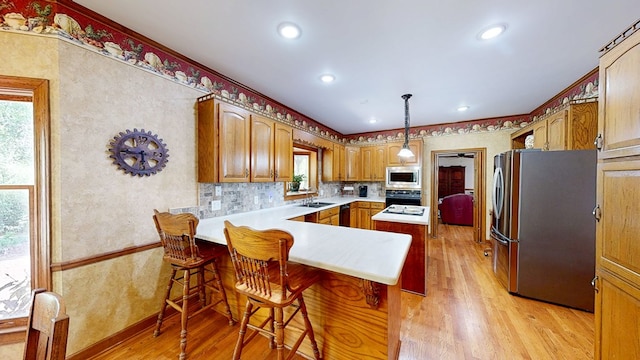 1109 Sanitary Dairy Rd, Cowarts, AL 36321 - kitchen with light wood-style flooring, a peninsula, a sink, and appliances with stainless steel finishes
