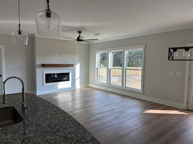 living room with hardwood / wood-style flooring, ceiling fan, crown molding, and sink