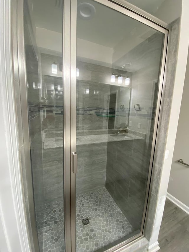 bathroom featuring hardwood / wood-style floors and a shower with door