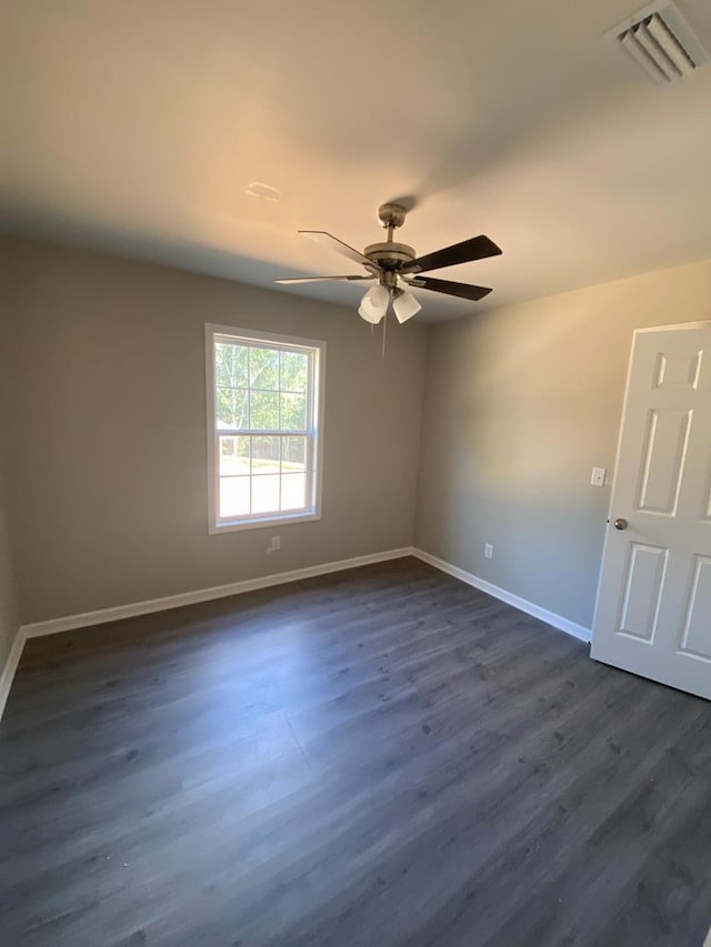 empty room with ceiling fan and dark wood-type flooring