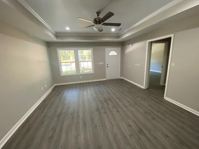 foyer with a tray ceiling, ceiling fan, dark hardwood / wood-style flooring, and ornamental molding