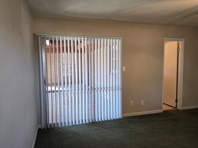 unfurnished room featuring carpet, a textured ceiling, and baseboards