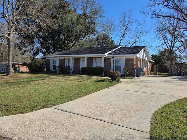 view of front of house with driveway, a front lawn, and brick siding