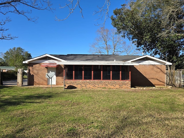 rear view of property with brick siding and a yard