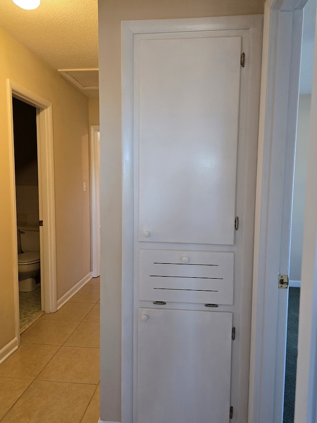 interior space with a textured ceiling and baseboards